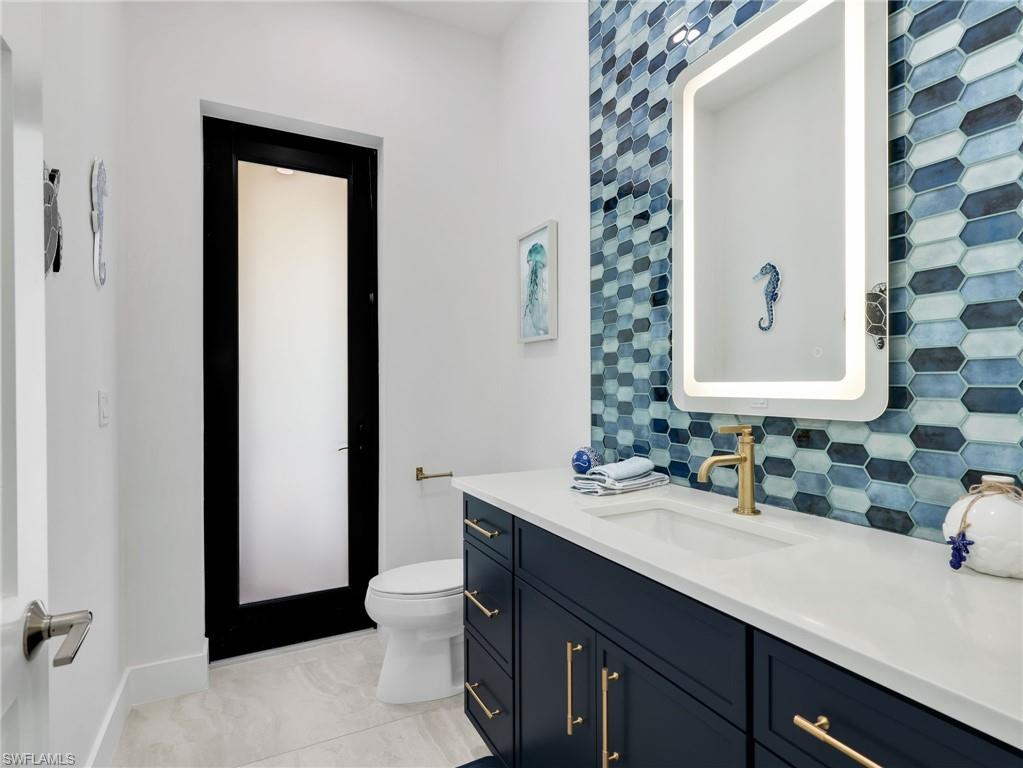 Bathroom with tasteful backsplash and vanity