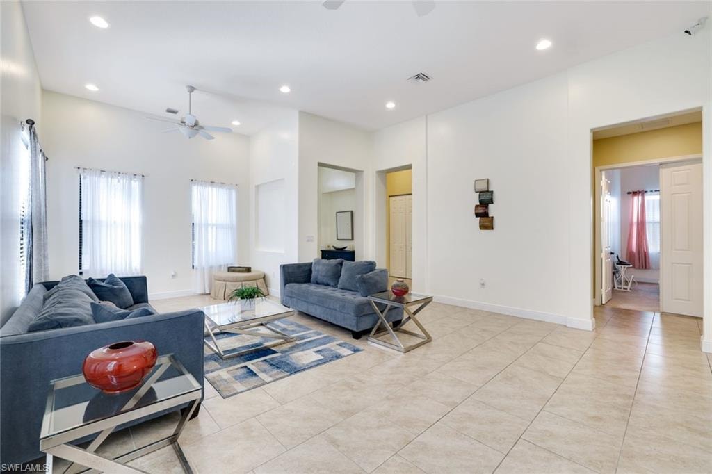 Living area featuring recessed lighting, light tile patterned flooring, and a ceiling fan