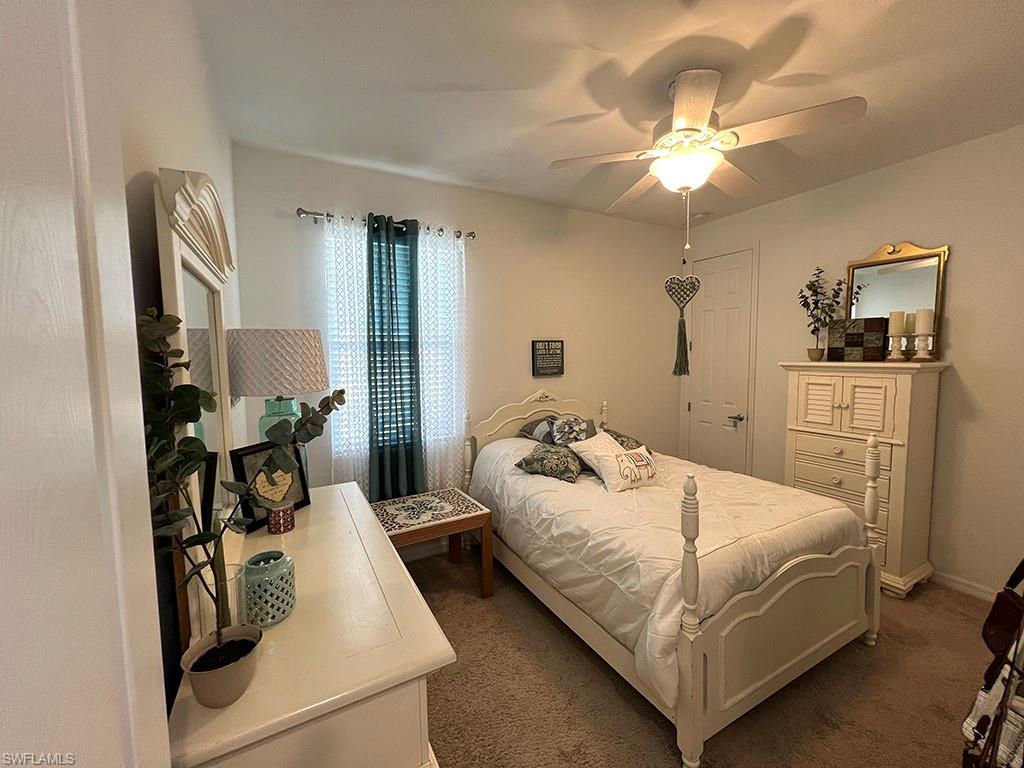 Bedroom with dark colored carpet and a ceiling fan