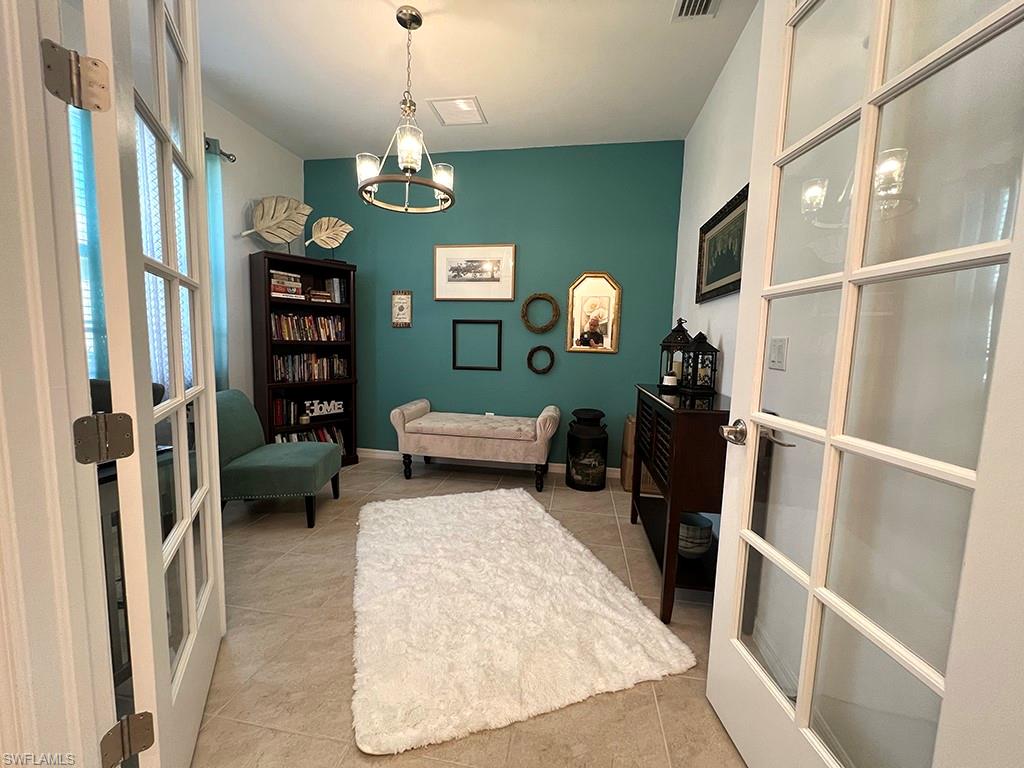 Home office featuring french doors, suspended lighting, and light tile patterned flooring