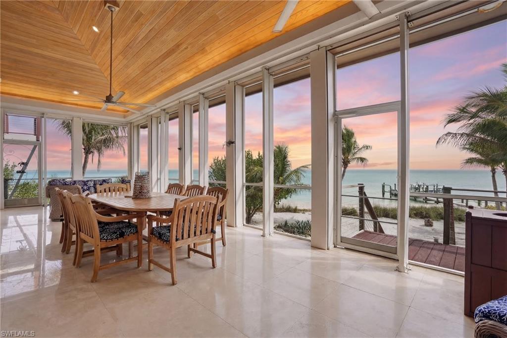 Sunroom / solarium with wooden ceiling, a water view, and expansive windows