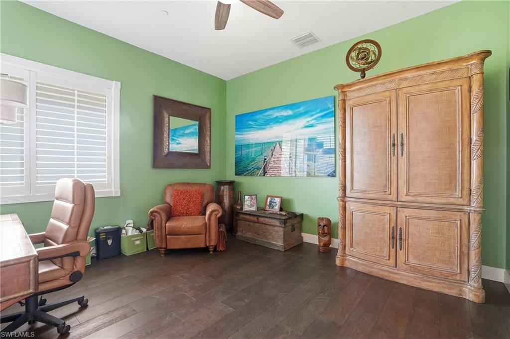Office area featuring dark wood finished floors and ceiling fan