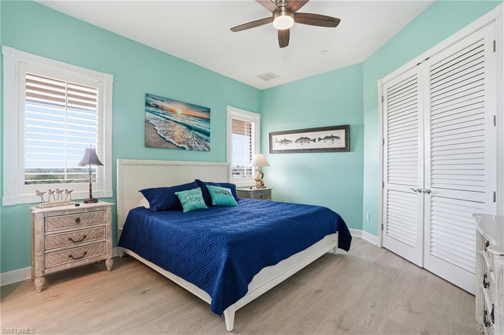 Bedroom with light wood-style floors, a closet, and ceiling fan
