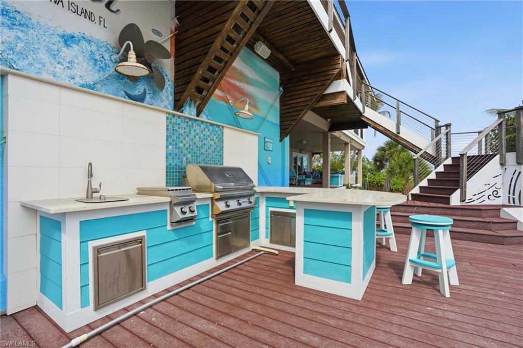 Deck featuring stairs and area for grilling