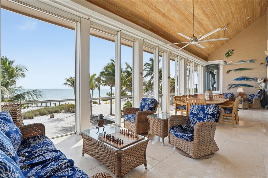 Sunroom featuring a water view, a vaulted wood ceiling, and tile patterned floors