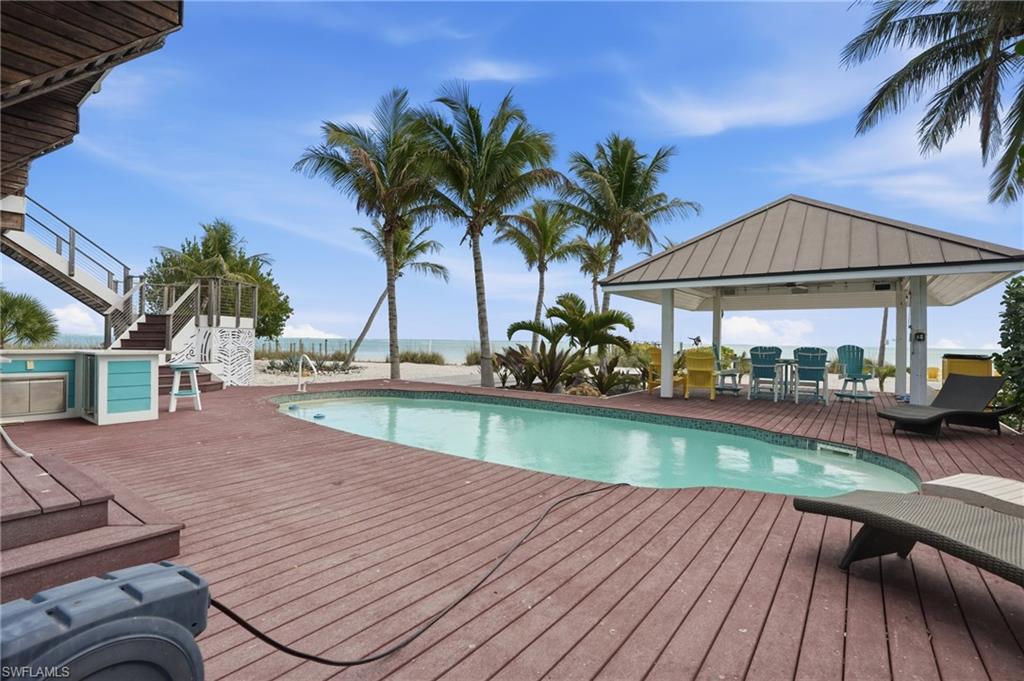 Swimming pool featuring a deck with water view and a gazebo