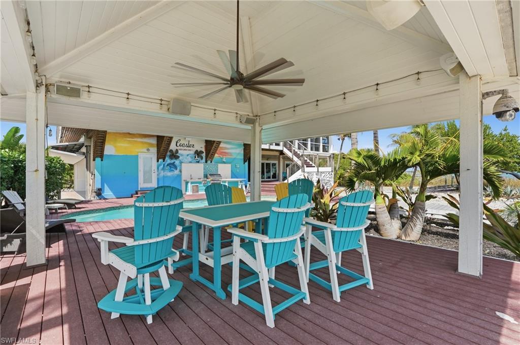 Wooden terrace featuring ceiling fan and outdoor dining area