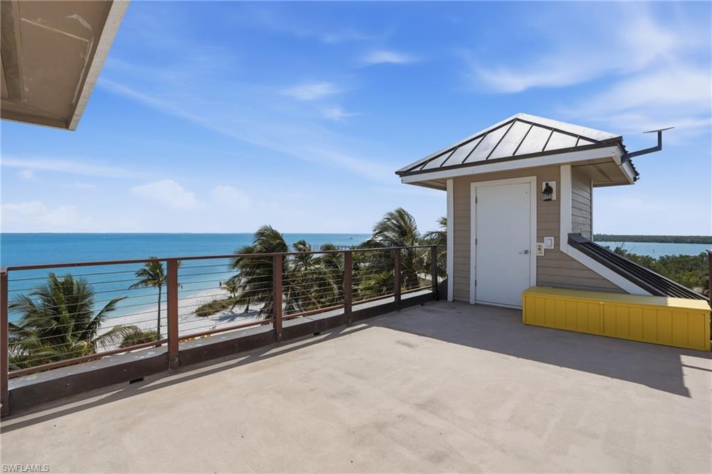 View of patio / terrace with view of water and beach