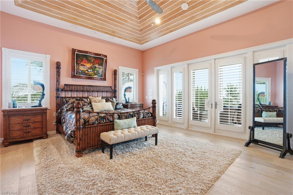 Bedroom with french doors, access to outside, light wood-type flooring, and a ceiling fan