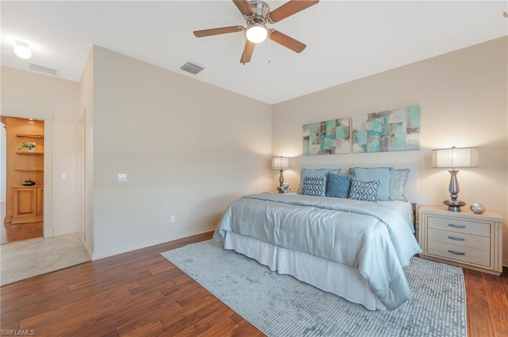 Spacious room featuring wood-finish tile flooring, a ceiling fan with integrated lighting, and neutral wall tones