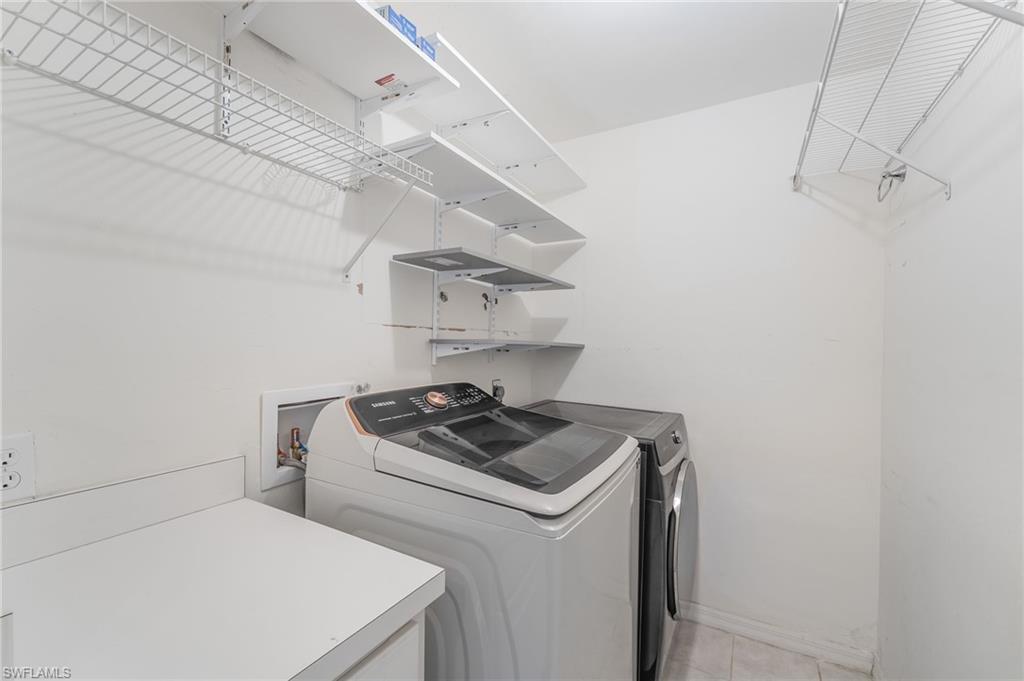 Dedicated laundry space featuring white wire shelving, wall-mounted adjustable shelving, and a white countertop for utility