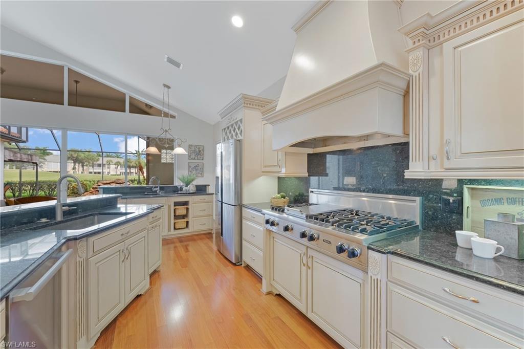 Gourmet kitchen featuring a vaulted ceiling and wood-finish flooring