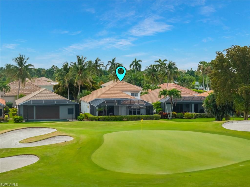 Residence featuring a tile roof, screened lanai, and an expansive golf course frontage with a putting green