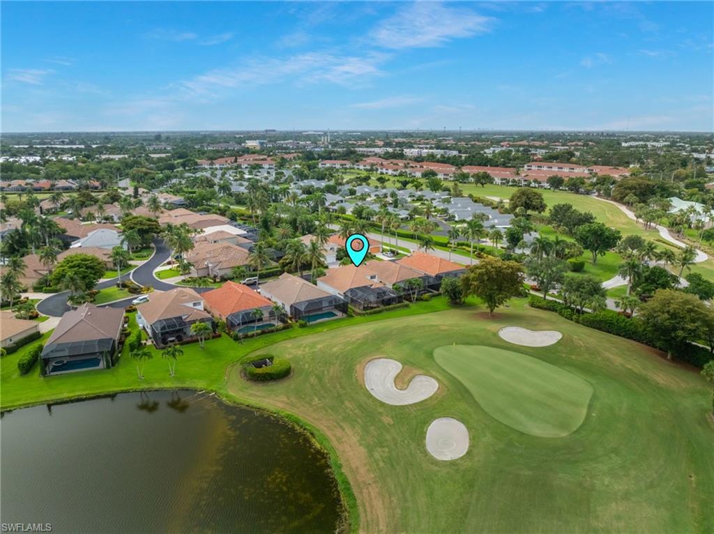 Residential property situated alongside a golf course, featuring a private pool with a screen enclosure, and a tiled roof