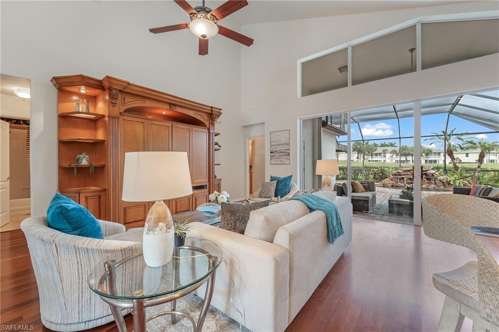 Spacious living area featuring wood-finish flooring and  entertainment center with carved wood detailing