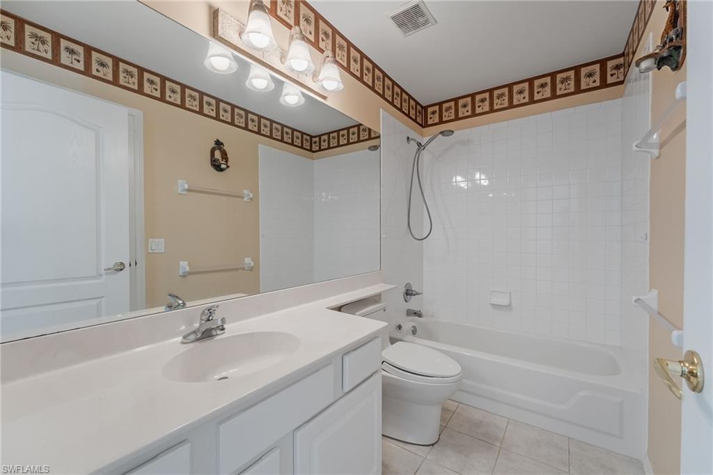 Bathroom featuring a single vanity with an integrated sink, polished chrome faucet, and expansive mirror