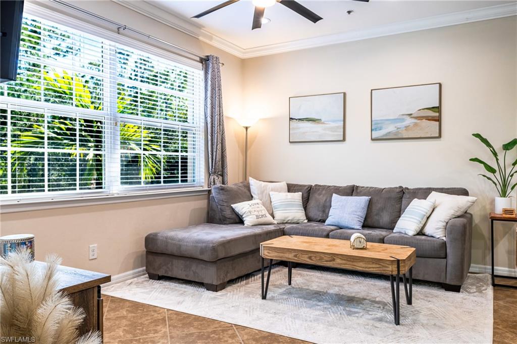 Tiled living room with crown molding and ceiling fan
