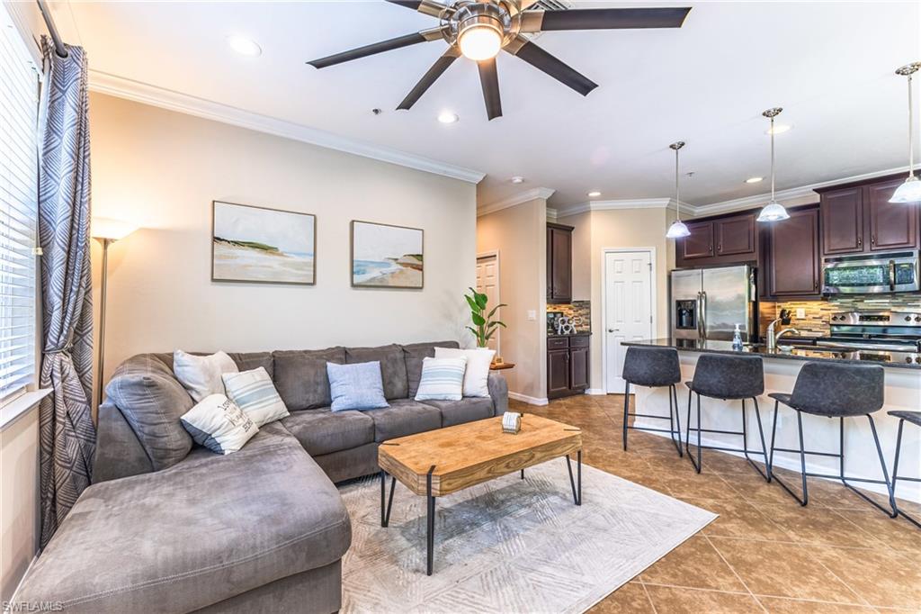 Living area featuring ceiling fan, ornamental molding, recessed lighting, and light tile patterned flooring