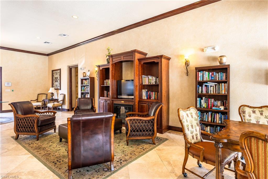 Living room featuring crown molding and a glass covered fireplace