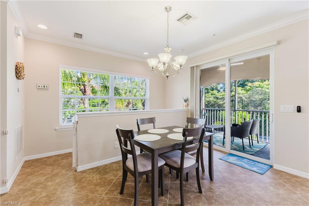 Dining space with suspended lighting and ornamental molding