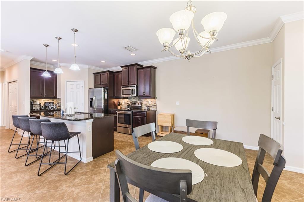 Dining room featuring ornamental molding, hanging lights, and light tile patterned flooring
