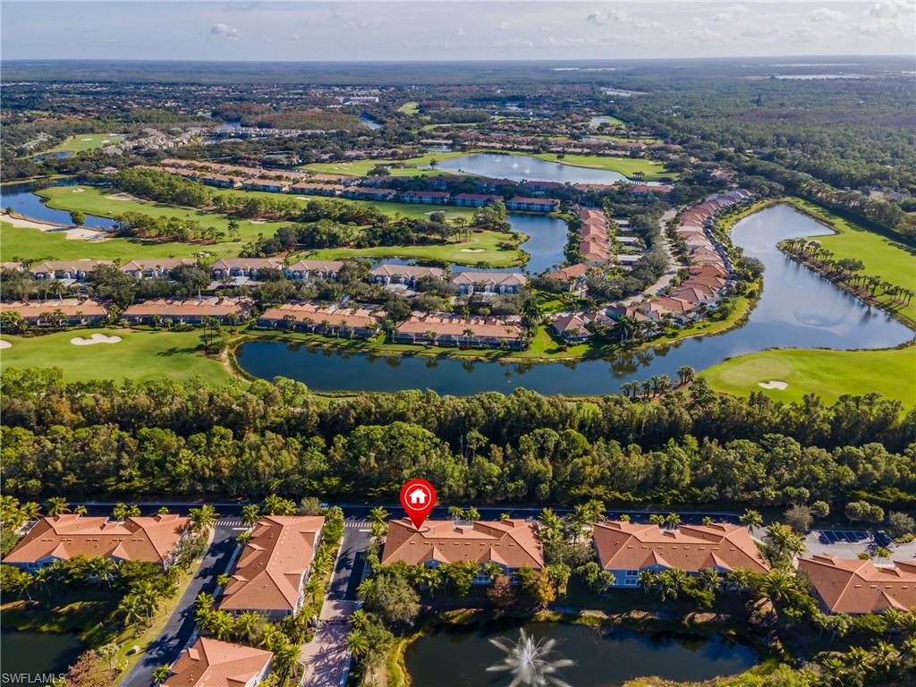 Aerial view of property and surrounding area featuring a large body of water, a golf club, and nearby suburban area