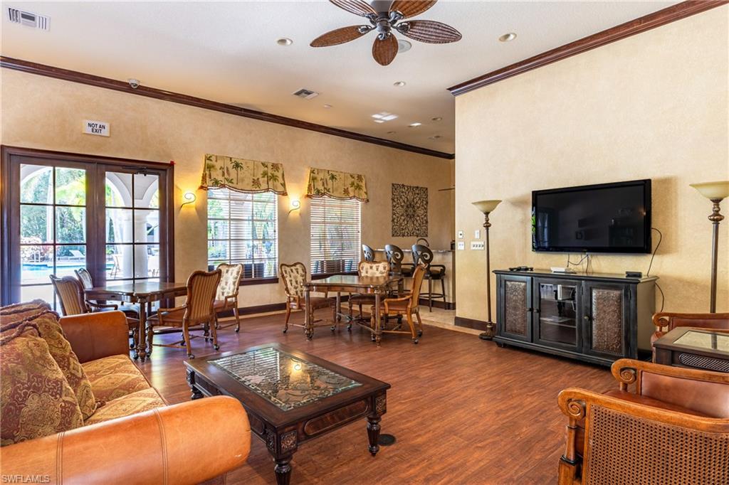 Living room featuring crown molding, ceiling fan, wood finished floors, and a textured wall