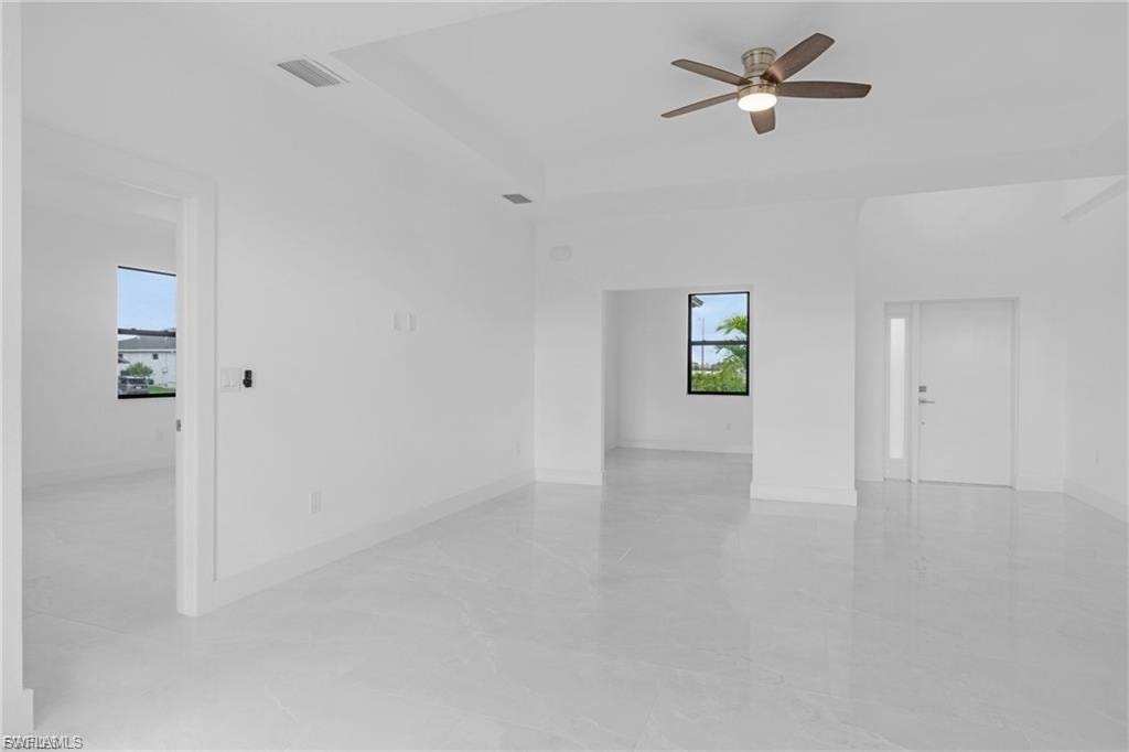 Empty room featuring ceiling fan and baseboards