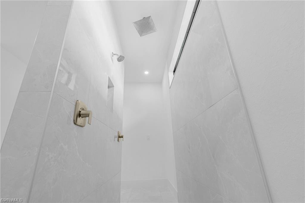 Bathroom featuring a tile shower and recessed lighting