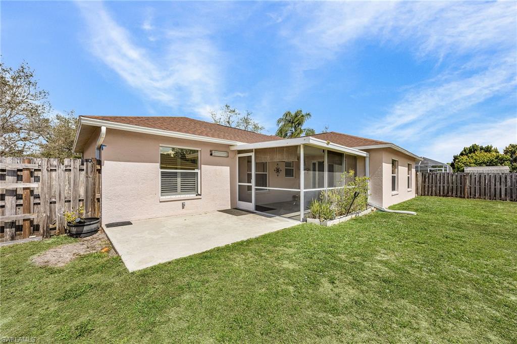 Rear view of property featuring a patio, a fenced backyard, stucco siding, and a sunroom
