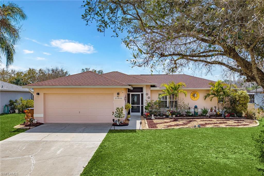 Ranch-style house featuring stucco siding, an attached garage, driveway, and a front yard