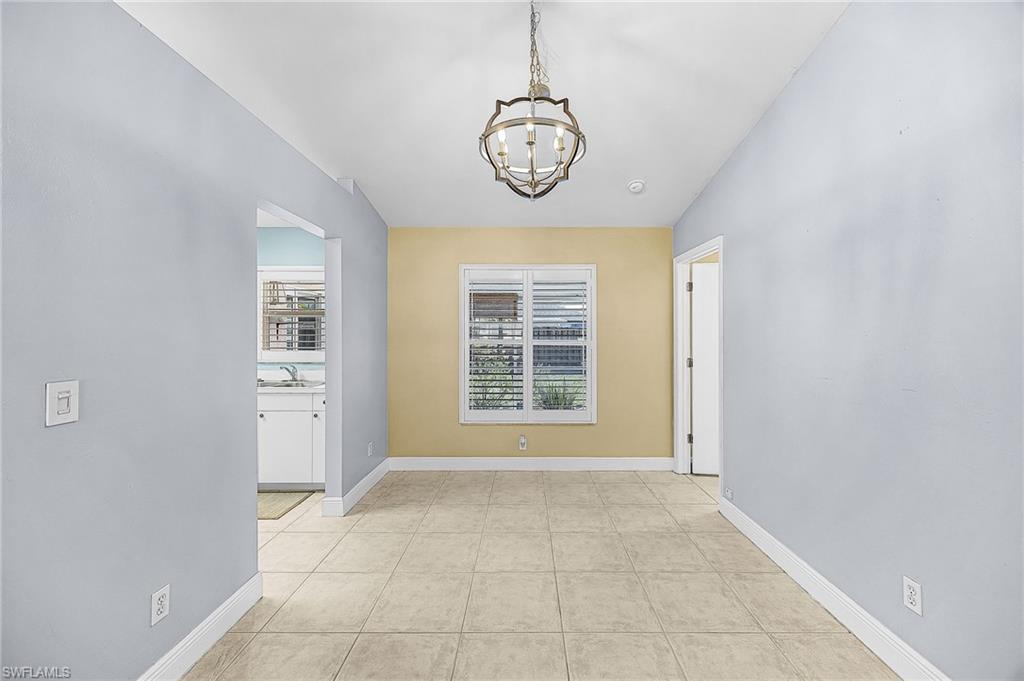 Spare room featuring a chandelier and light tile patterned floors
