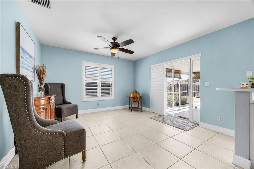 Living area featuring a ceiling fan and light tile patterned flooring