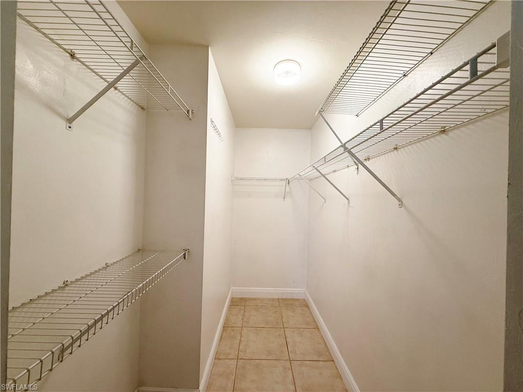 Walk in closet with light tile patterned floors