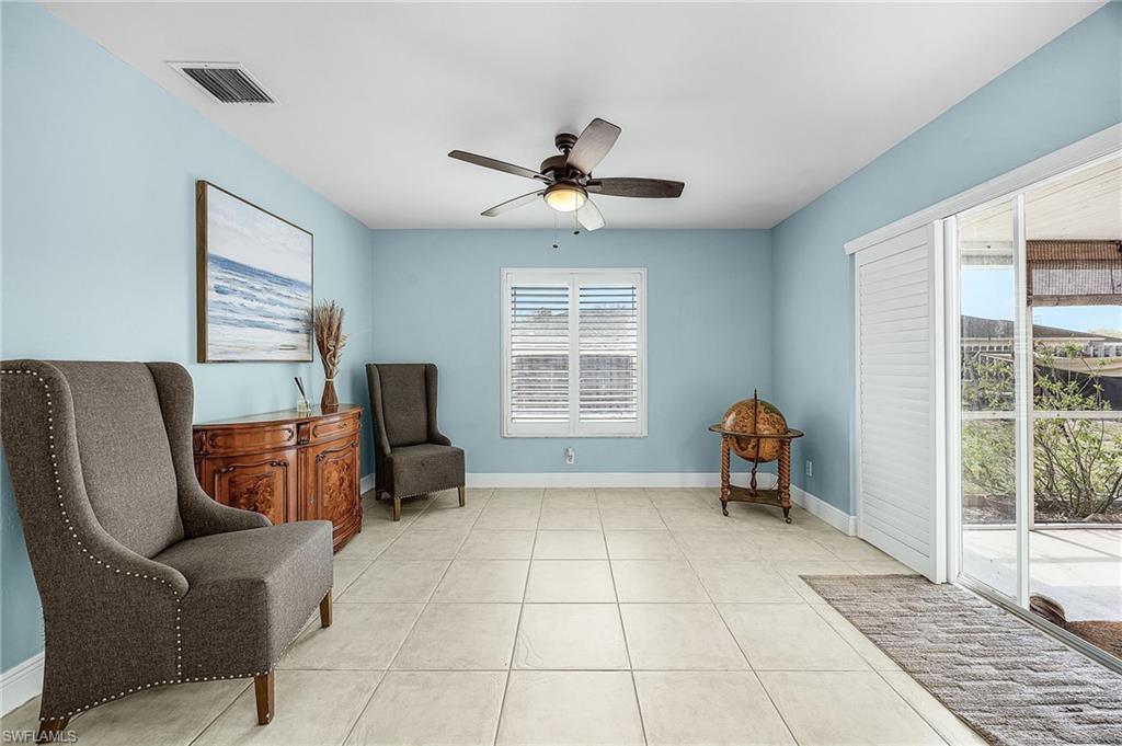 Living area featuring a ceiling fan and light tile patterned floors