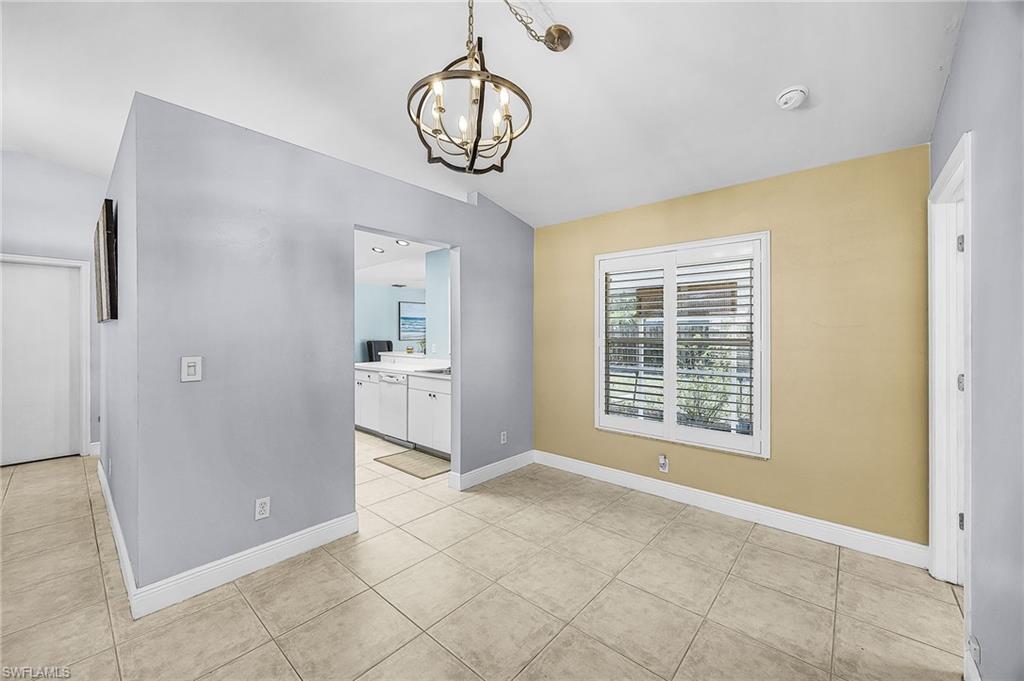 Unfurnished dining area with a chandelier and light tile patterned floors