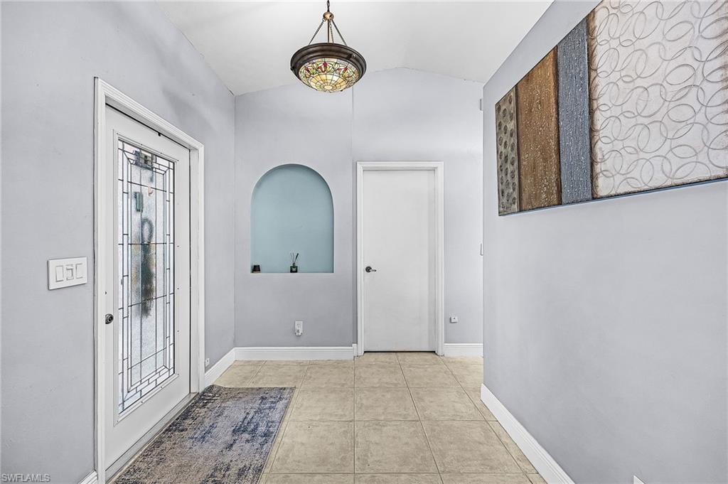 Foyer with vaulted ceiling and light tile patterned flooring