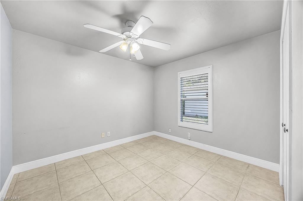 Spare room with ceiling fan and light tile patterned flooring