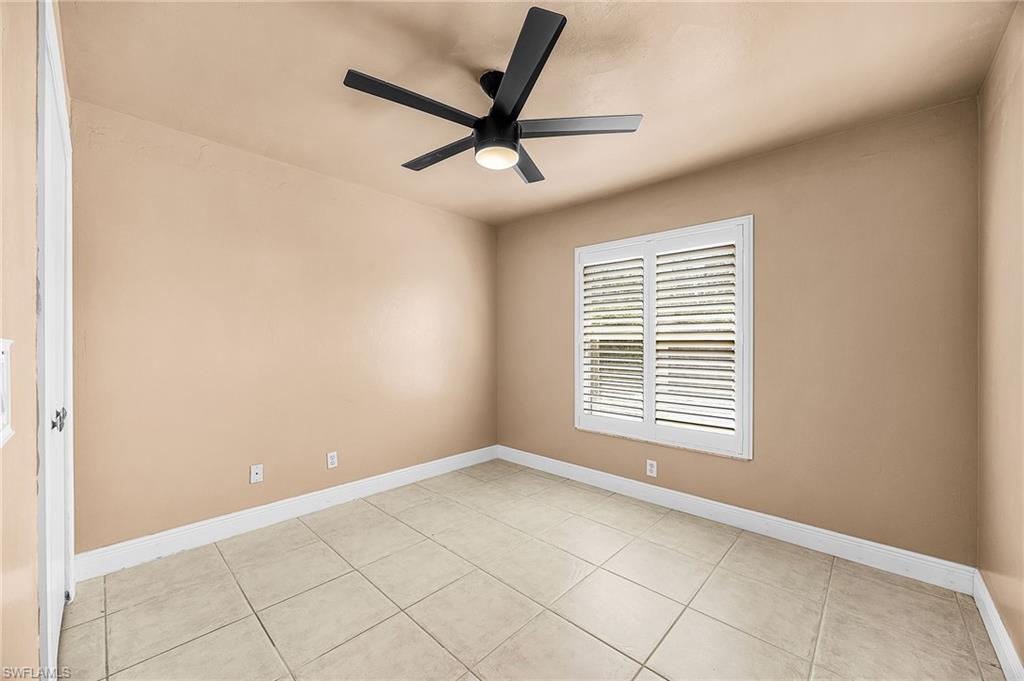 Empty room featuring a ceiling fan and light tile patterned flooring