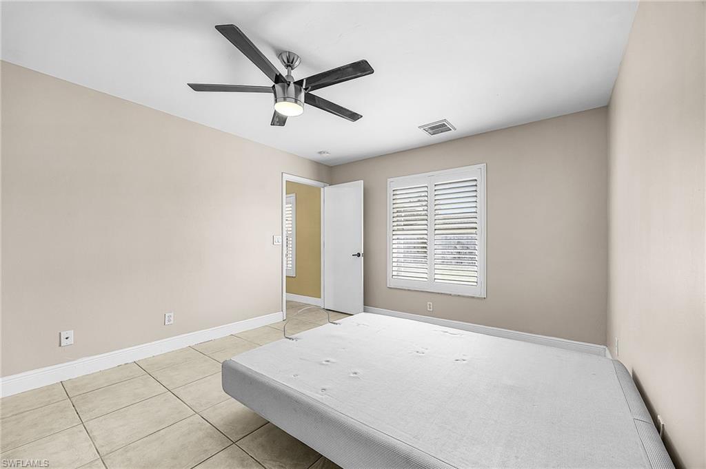 Bedroom with a ceiling fan and light tile patterned floors