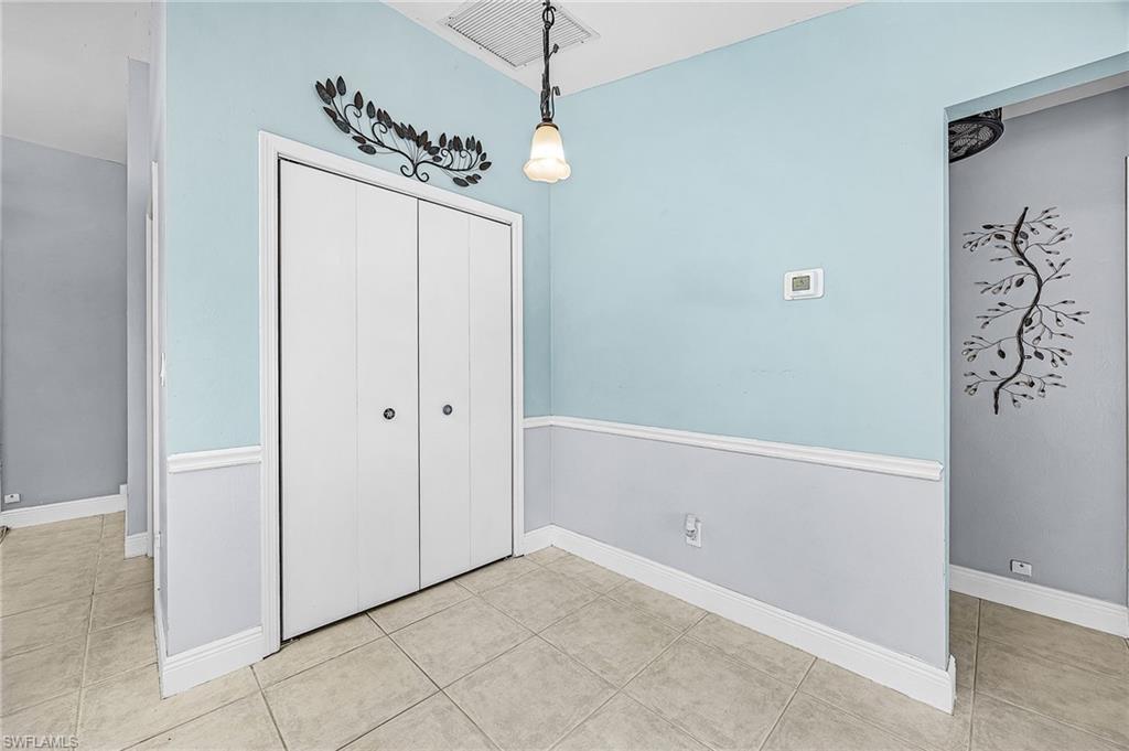 Unfurnished dining area featuring light tile patterned flooring and baseboards