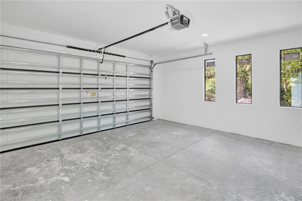 Garage featuring a garage door opener and recessed lighting