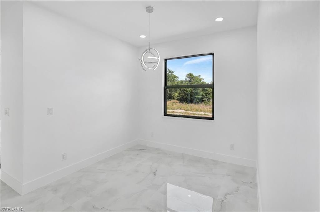 Unfurnished room featuring recessed lighting and light marble finish floors