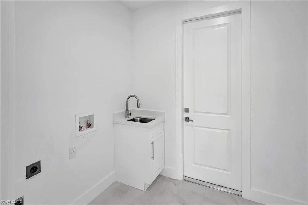 Laundry room featuring hookup for a washing machine, electric dryer hookup, and cabinet space