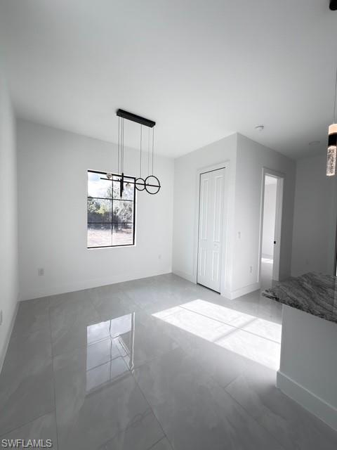 Unfurnished dining area with baseboards