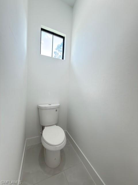 Bathroom with toilet and light tile patterned floors