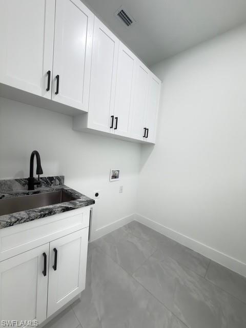 Laundry room with cabinet space, hookup for a washing machine, and hookup for an electric dryer
