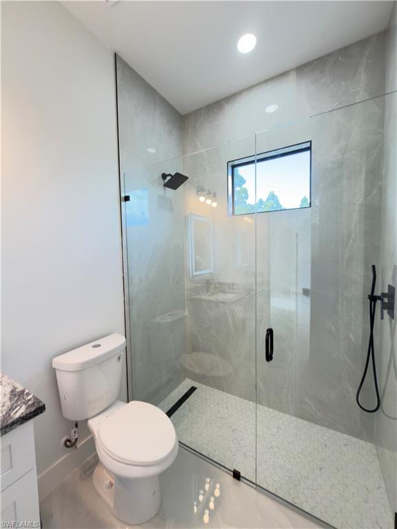 Full bathroom with a marble finish shower and vanity
