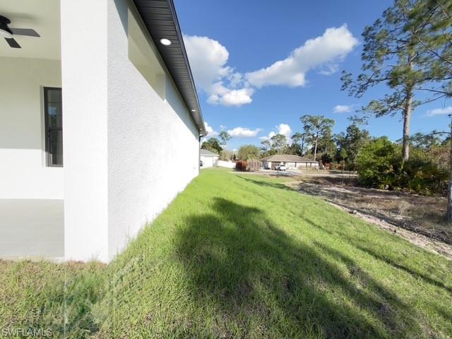 View of green lawn featuring a ceiling fan