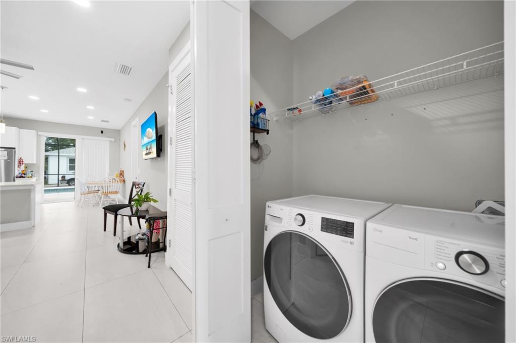Laundry area with washer and dryer, recessed lighting, and light tile patterned floors